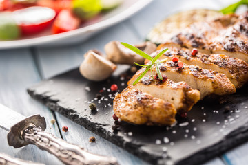 Grilled chicken breast on slate board.