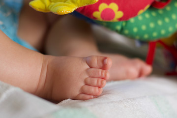 close up of baby boy feet  sleeping near colored toys