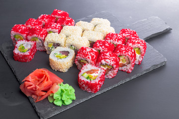 Obraz na płótnie Canvas Japanese restaurant, sushi roll on black slate plate.