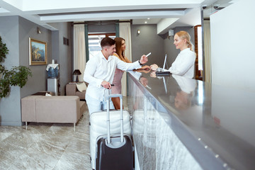 couple near reception desk in hotel
