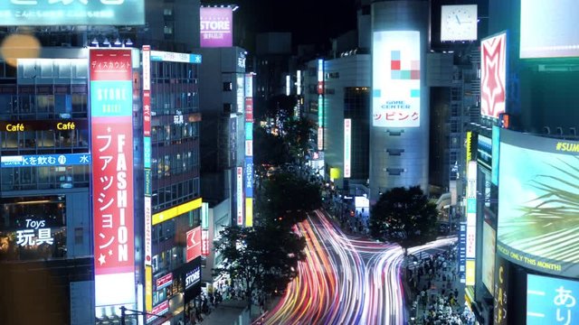 High Angle Time Lapse Shot of Tokyo, Big City Center With Skyscrapers, Glowing Advertising Billboards, Heavy Traffic and Crowds of People at Night.