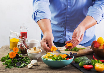 Obraz na płótnie Canvas man cooking a vegetarian salad