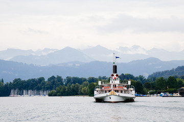Ferry on Lake with cloudy mountain in Luzern, Switzerland