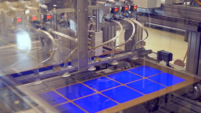 An automative machine is discharging a stencil plate from solar cells