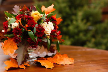 autumn flower composition with roses, chrysanthemum and maple leaves