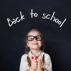 Back to school portrait of lovely schoolgirl with thumb up