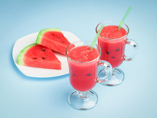 Smoothies cooked from the pulp of watermelon in glass glasses on a blue background