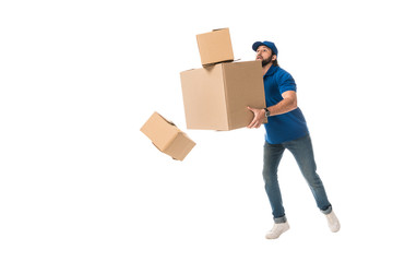 full length view of delivery man holding stacked cardboard boxes falling isolated on white