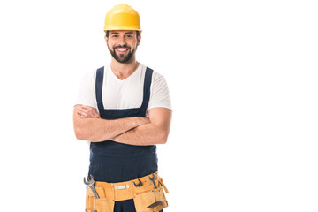 handsome happy workman in hard hat and tool belt standing with crossed arms and smiling at camera...