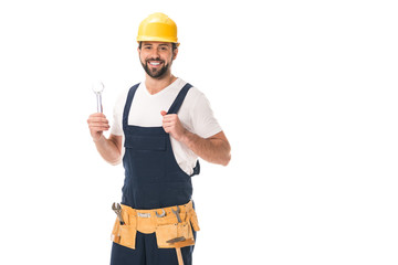 happy workman holding wrench and smiling at camera isolated on white