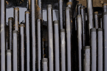 Oil Drill pipe. Rusty drill pipes were drilled in the well section. Downhole drilling rig. Laying the pipe on the deck. View of the shell of drill pipes laid in courtyard of the oil and gas warehouse.