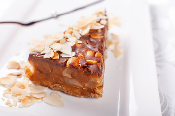 Nuts cake. Piece of Cake with almond ant peanut on a Plate. Sweet food. Sweet dessert. Food background. Close up.