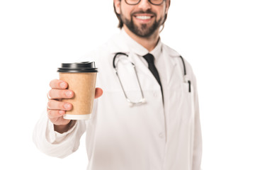 cropped shot of smiling doctor in white coat holding paper cup with coffee to go isolated on white