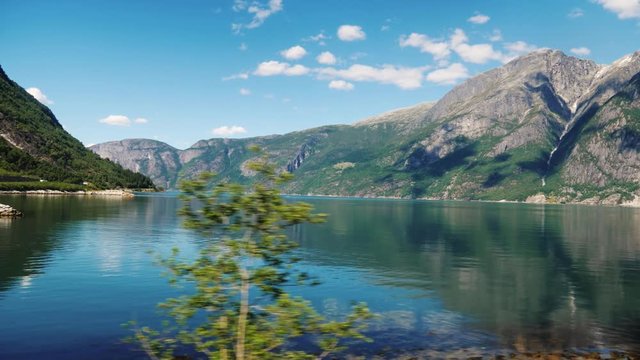 A beautiful fjord in Norway, the mountains are reflected in the water. View from the window of the traveling bus