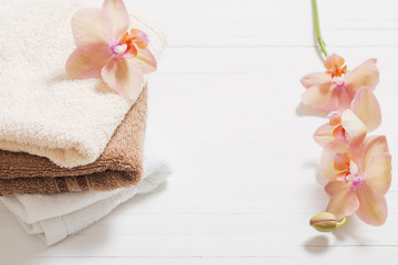 orchid with towels on white wooden background