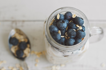Overnight oats with blueberry on wooden table. Homemade yogurt with whole grain oats. Healthy...