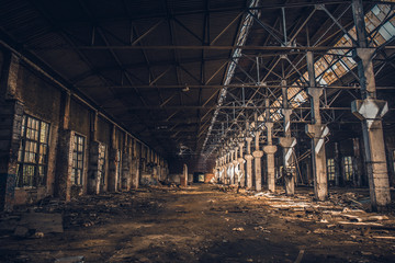 Abandoned and ruined dark industrial creepy warehouse inside with columns, corridor or tunnel view,...