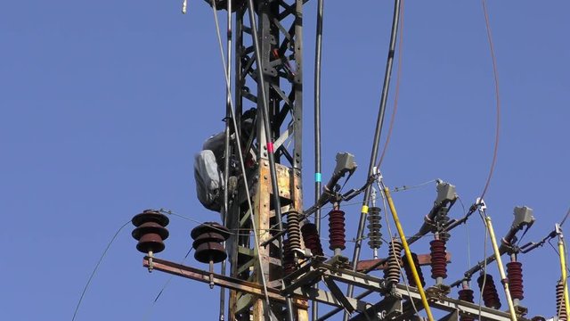 Electricians fixing high voltage electrical lines, replacing a transformer