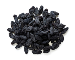 Heap of black raisins isolated on white background. Top view of dried grapes.
