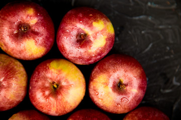Fresh organic red apples on black background.