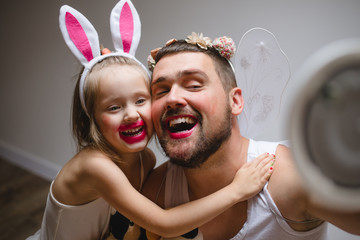 Little daughter and father have fun, dressing in princess costume, daddy makeup