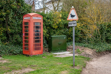 Fototapeta na wymiar Telephone booth and sign & symbol: Wild fowl - seen in Coltishall, The Broads, Norfolk, England, UK