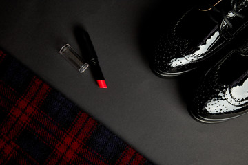 Autumn stylish woman's outfit. Red striped coat, black oxford shoes