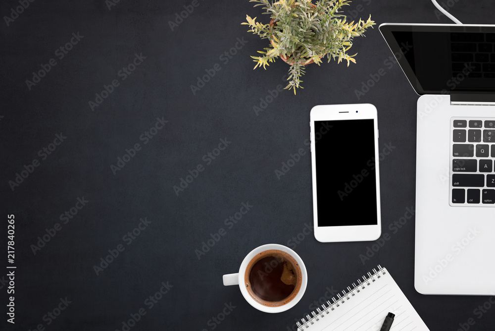 Aufkleber smart phone and laptop on black office desk with copy space on left side. blank screen on devices fo