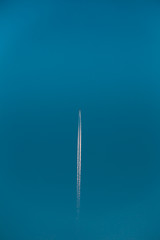 Contrail In Blue Sky. Aircraft Plane In Clear Sunny Sky Background