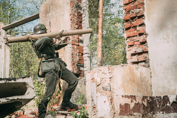 Fototapeta premium Re-enactor Dressed As German Wehrmacht Infantry Soldier In World War II Open Fire From Anti-tank Cannon During Historical Reenactment.