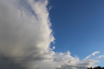 Rain clouds clash with deep blue sky