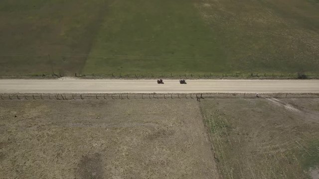 Aerial Drone View Tracking ATVs on Dirt Road Panning Left and Front
