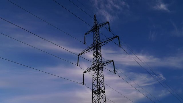 Electricity pylons and clouds sky on the background. Timelapse. 4K