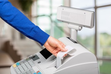 Cash register with LCD display and worker's hand holding receipt