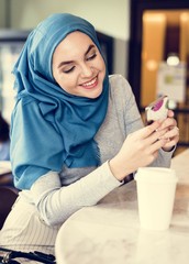 Islamic woman using using smart phone and smiling
