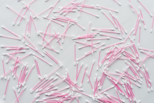 top view of scattered pink cotton swabs isolated on white, beauty concept