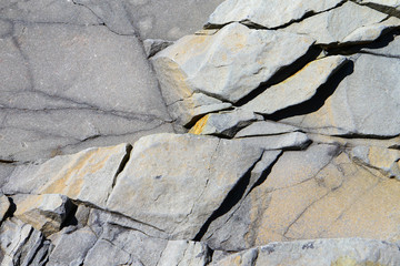 Grey stone surface detailed texture with cracks. Sea limestone.