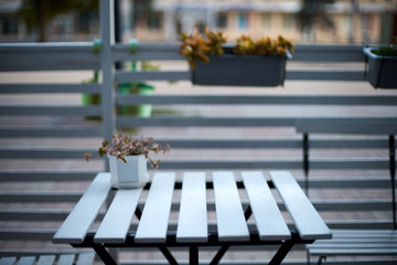 White wooden planks table, chairs and horizontal fence of cafe in the street. Background for product placement. Isolated outdoor empty european restaurant or coffee shop exterior. No people.