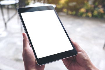 Mockup image of woman's hands holding black tablet pc with white blank desktop screen in cafe