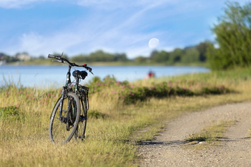 Obraz na płótnie Canvas Fahrrad am Meer mit Aussicht auf den Mond in Urlaubsgegend.