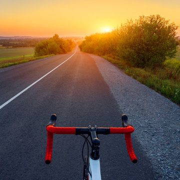 Bicycle on a road. Beautiful sunset landscape with road bike