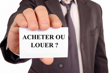 Homme tenant une carte sur laquelle est écrit acheter ou louer 