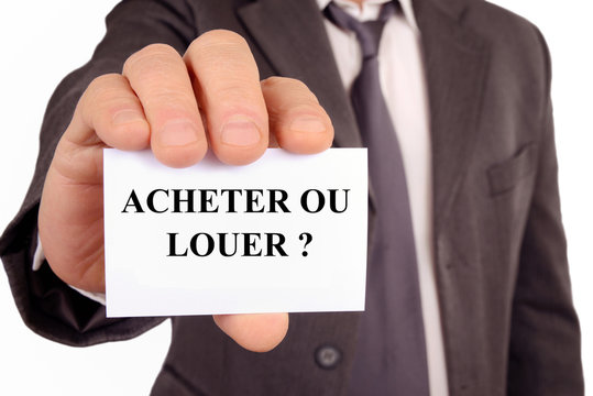 Homme tenant une carte sur laquelle est &eacute;crit acheter ou louer 