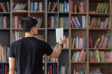 Man picking up book from shelf