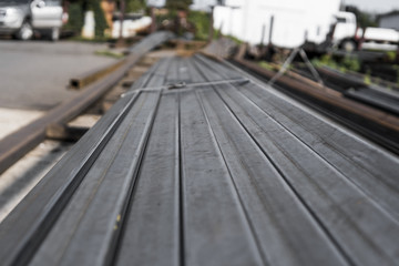 Square flat-rolled pipe metal profile in packs at the warehouse of metal products. Weathered metals...