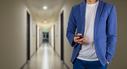 Man using phone in building hallway walk way