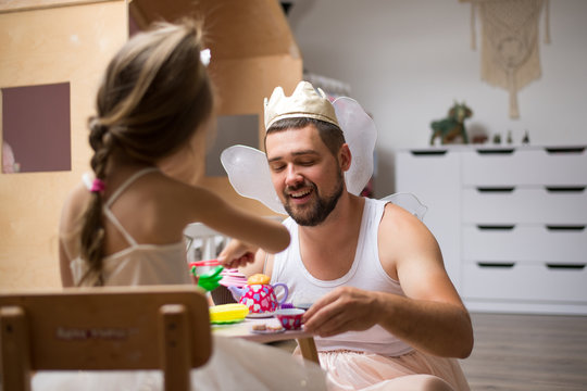 Little daughter and father have fun, dressing in princess costume, daddy makeup