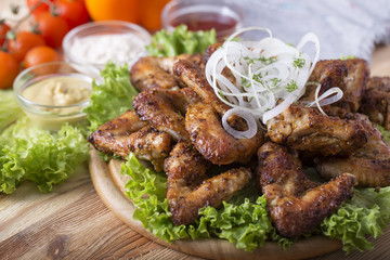Bbq chicken wings wth onion on wooden board