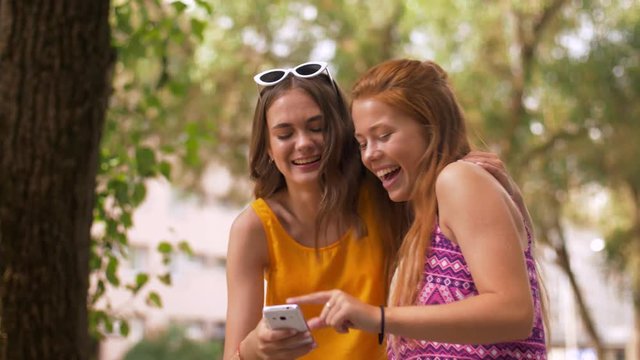 friendship, leisure and technology concept - smiling teenage girls taking selfie by smartphone in summer park