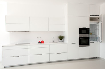 White kitchen interior. Minimalistic interior design. Modern furniture and built-in appliances.